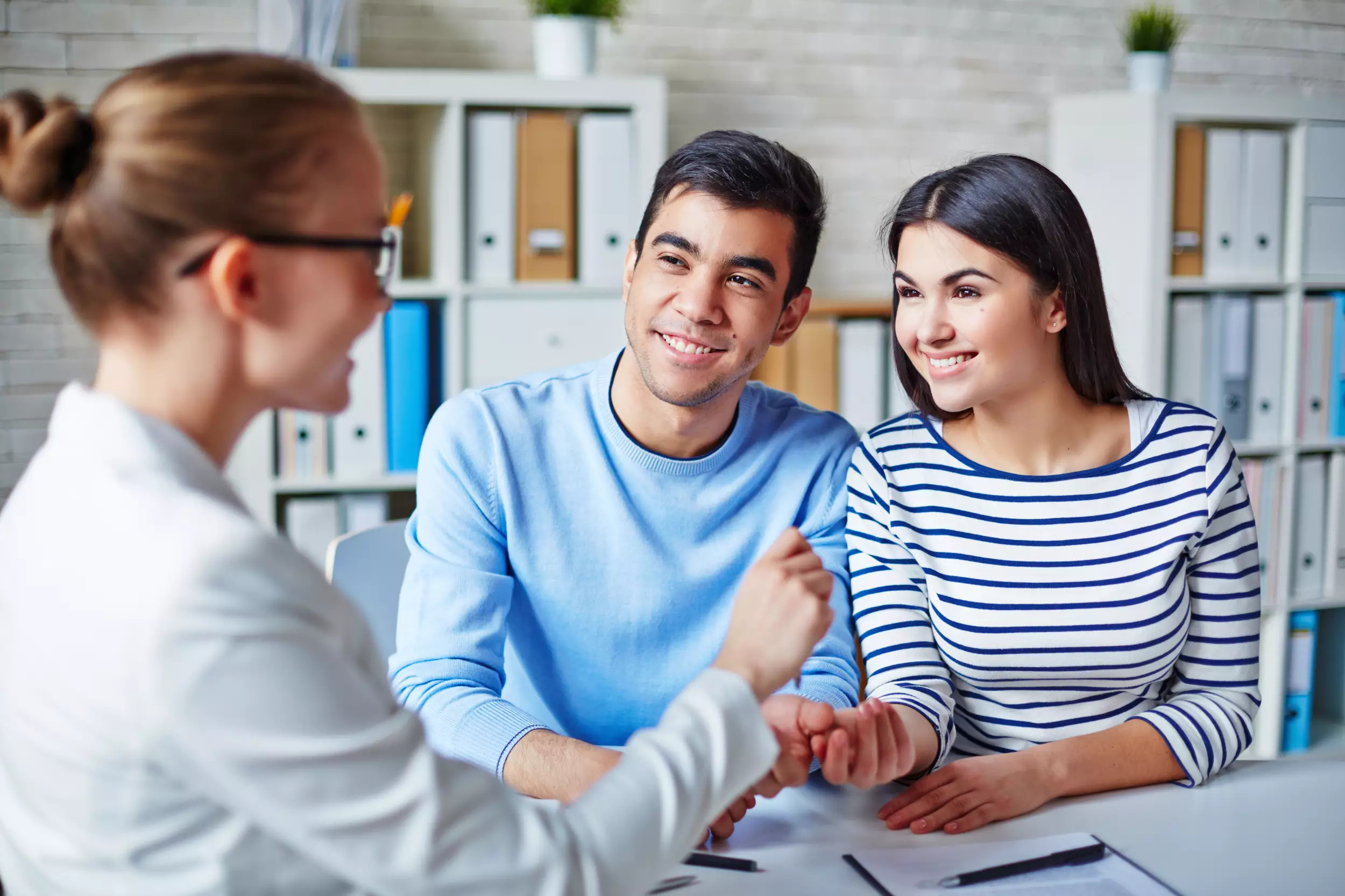 Young couple being handed keys to a new house